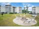 Outdoor seating area with a fire pit, surrounded by lush green lawn and mature trees at 4350 Intercoastal Dr. # 1101, Little River, SC 29566