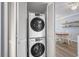 A stacked washer and dryer set in the laundry closet, with a glimpse of the dining area at 4601 N Ocean Blvd. # 203, North Myrtle Beach, SC 29582