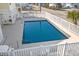 Rectangular community pool surrounded by a white fence and several chairs and tables at 4601 N Ocean Blvd. # 203, North Myrtle Beach, SC 29582