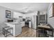 Well-lit kitchen with stainless steel appliances, white cabinets, breakfast bar with stools, and wood-look flooring at 4801 N Ocean Blvd. # 3E, North Myrtle Beach, SC 29582