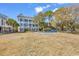 Backyard view of a three-story house with a pool, backyard, and lounge seating by the pool at 534 South Creekside Dr., Murrells Inlet, SC 29576