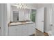 Bright bathroom with double sinks, white cabinets, large mirror, and neutral-toned tile flooring at 534 South Creekside Dr., Murrells Inlet, SC 29576