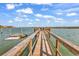 Wooden dock on the water with railings on either side, leading to an extended dock with seating at 534 South Creekside Dr., Murrells Inlet, SC 29576