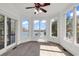 Bright sun room featuring numerous windows and a ceiling fan, offering stunning water views at 534 South Creekside Dr., Murrells Inlet, SC 29576