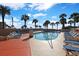 Pool area with lounge chairs and palm trees, with resort in background at 5523 N Ocean Blvd. # 1506, Myrtle Beach, SC 29577