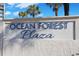 Elegant entrance sign displaying 'Ocean Forest Plaza' on a textured wall, framed by lush palm trees at 5523 N Ocean Blvd. # 1506, Myrtle Beach, SC 29577