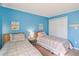 Comfortable blue bedroom with twin beds, closet, and beach-themed wall decor at 613 South Ocean Blvd. # O-2, North Myrtle Beach, SC 29582