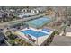 Aerial view of community pool, tennis courts, and residences under a sunny, blue sky at 617 S 13Th Ave. # 116, Surfside Beach, SC 29575