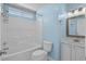 Clean bathroom featuring a shower-tub combo, toilet, vanity, and neutral-colored hardware and fixtures at 9840 Conifer Ln., Murrells Inlet, SC 29576