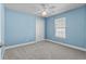 Bright bedroom with a ceiling fan, window, and a closet featuring light blue walls and neutral carpet at 9840 Conifer Ln., Murrells Inlet, SC 29576