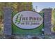 Welcome to The Pines of St. James sign featuring decorative green text and stone accents at 9840 Conifer Ln., Murrells Inlet, SC 29576