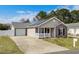 Attractive one-story home with vinyl siding, solar panels, front porch, and attached garage in a Gathering-friendly neighborhood at 9840 Conifer Ln., Murrells Inlet, SC 29576