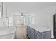 Open kitchen with white cabinets, a blue island, stainless steel appliances, and wood-look flooring at 9840 Conifer Ln., Murrells Inlet, SC 29576