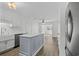 Modern kitchen with white cabinetry, an island with a marble top, a stainless steel dishwasher, and laminate flooring at 9840 Conifer Ln., Murrells Inlet, SC 29576