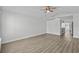 Spacious living room featuring laminate floors, ceiling fan, white walls, and seamless transition to the kitchen at 9840 Conifer Ln., Murrells Inlet, SC 29576