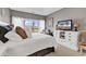 This bedroom has a king bed, large windows, and a white dresser with a TV on it at 104 Cypress Point Ct. # 302, Myrtle Beach, SC 29579