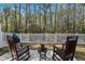 Secluded backyard with a white picket fence, mature trees, and a patio with comfortable seating and a grill at 115 Galil Dr. # B, Myrtle Beach, SC 29579