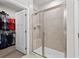 Modern bathroom featuring a glass shower, a seat, and a view into the walk-in closet at 115 Galil Dr. # B, Myrtle Beach, SC 29579