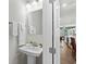 A charming half-bathroom featuring elegant pedestal sink, complemented by soft, neutral tones and modern fixtures at 115 Galil Dr. # B, Myrtle Beach, SC 29579