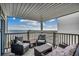 Relaxing covered balcony featuring comfortable patio furniture with view of the sandy beach and fishing pier at 126 N Waccamaw Dr. # 203, Garden City Beach, SC 29576