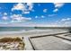 Expansive view of a sandy beach with a fishing pier, crashing waves, and clear skies for a serene coastal experience at 126 N Waccamaw Dr. # 203, Garden City Beach, SC 29576