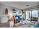 Cozy living room with a futon and a sliding glass door to a covered balcony with a view of the ocean at 126 N Waccamaw Dr. # 203, Garden City Beach, SC 29576