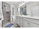 Modern bathroom features a double vanity with gray cabinets and a tiled shower with a glass door at 138 Marblehead Dr., Little River, SC 29566