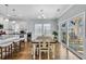 Charming dining space boasts a farmhouse table, modern lighting, and sliding glass doors with sunlit outdoor views at 138 Marblehead Dr., Little River, SC 29566