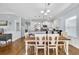 Bright dining area featuring a farmhouse-style table, elegant chandelier, and a view of the modern kitchen at 138 Marblehead Dr., Little River, SC 29566