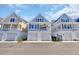 Charming coastal homes boast covered garages and spacious balconies under a sunny blue sky at 138 Marblehead Dr., Little River, SC 29566