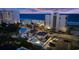 Aerial view of a beach home with a private pool next to commercial buildings and the ocean at 1420 S Ocean Blvd., North Myrtle Beach, SC 29582