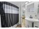 Bright bathroom features a pedestal sink and a shower with modern black and gray shower curtain at 1420 S Ocean Blvd., North Myrtle Beach, SC 29582