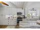 Well-lit kitchen with white cabinets, granite countertops, and modern appliances at 1420 S Ocean Blvd., North Myrtle Beach, SC 29582