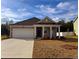 Charming single-story home with a two-car garage and well-maintained lawn on a sunny day at 1431 Porchfield Dr., Conway, SC 29526