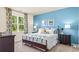 Spacious bedroom with blue accent wall, dresser, and window with natural light shining through at 1431 Porchfield Dr., Conway, SC 29526