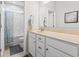 Clean bathroom with white vanity, neutral tile flooring, and shower with blue curtain at 145 Copper Leaf Dr., Myrtle Beach, SC 29588