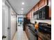 Modern kitchen with black appliances and wood cabinets leading to the living area and ocean views at 1501 S Ocean Blvd. # 633, Myrtle Beach, SC 29577