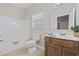 Bathroom with white shower-tub combo, tile floor, oak vanity, white toilet and a window at 160 Lazy Willow Ln. # 204, Myrtle Beach, SC 29577