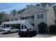 Inviting condo featuring a gray exterior, a white stairwell to a railed porch, and visible parking spaces at 160 Lazy Willow Ln. # 204, Myrtle Beach, SC 29577