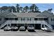 Condo featuring a gray exterior, a white stairwell to a railed porch, and parking spaces at 160 Lazy Willow Ln. # 204, Myrtle Beach, SC 29577