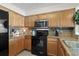Kitchen featuring granite countertops, stainless appliances, and wood cabinetry at 1625 S Ocean Blvd. # 1004, North Myrtle Beach, SC 29582