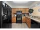 Kitchen with stainless steel appliances, warm wood cabinets, and light-colored granite countertops at 1625 S Ocean Blvd. # 1004, North Myrtle Beach, SC 29582
