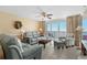 Living room with comfortable seating, ceiling fan, ocean view, and tile floors, creating a relaxing space at 1625 S Ocean Blvd. # 1004, North Myrtle Beach, SC 29582