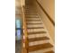 Wooden staircase with white risers and oak railing leading to the upper level of the house at 1719 Low Country Pl. # B, Myrtle Beach, SC 29577