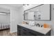 Modern bathroom features a double vanity with black cabinets and view of the nearby bedroom at 214 2Nd Ave. S, North Myrtle Beach, SC 29582