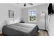 Well-lit bedroom featuring wood-look floors, a cozy bed, and modern decor at 214 2Nd Ave. S, North Myrtle Beach, SC 29582