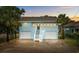 Charming two-story home with a ground-level garage, palm trees, and inviting staircase leading to the main entrance at 214 2Nd Ave. S, North Myrtle Beach, SC 29582