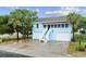Charming two-story home with a ground-level garage, palm trees, and inviting staircase leading to the main entrance at 214 2Nd Ave. S, North Myrtle Beach, SC 29582