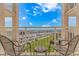 A balcony has chairs with great views overlooking the waterway, docks and grass at 2151 Bridge View Ct. # 1-803, North Myrtle Beach, SC 29582
