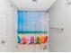 Bathroom features a shower with vibrant beach themed curtain and door nearby at 2151 Bridge View Ct. # 1-803, North Myrtle Beach, SC 29582